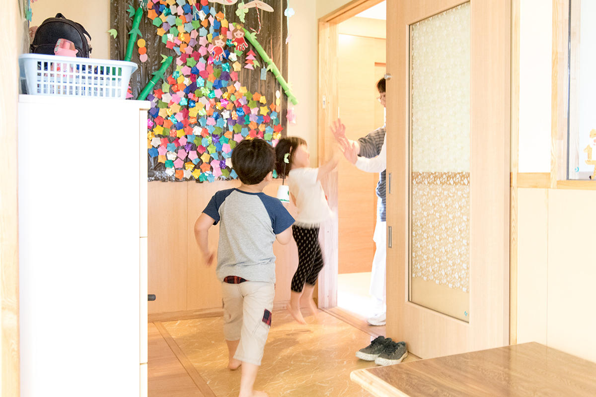 託児所玄関で元気よくバイバイしている子供たち